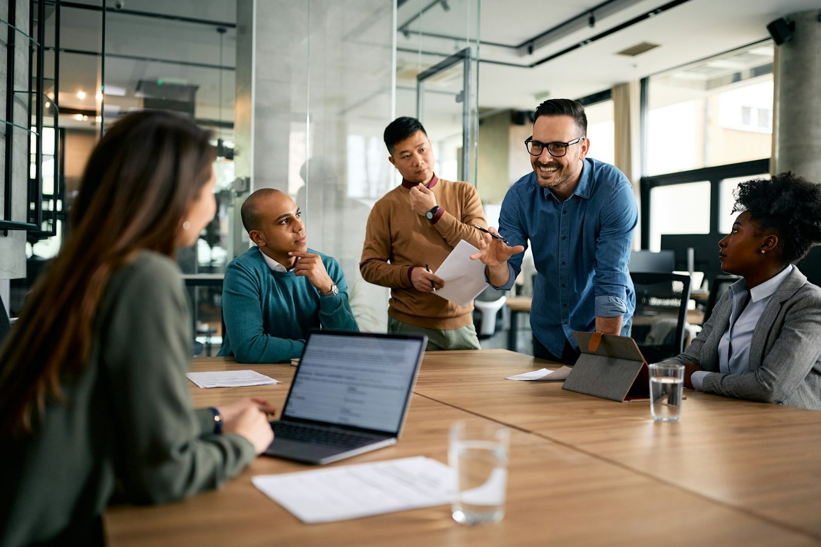 Happy entrepreneur leading a business meeting with coworkers in the office.